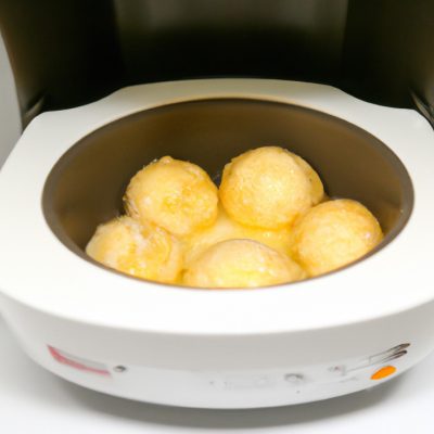Imagem de uma cocotte de cerâmica branca cheia de ovos cozidos na airfryer. Os ovos são cozidos até ficarem firmes e a gema ainda está líquida. A cocotte é colocada sobre um prato azul e branco.