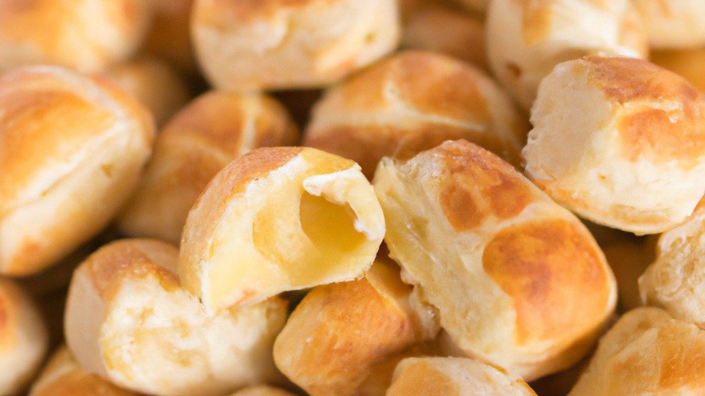 Pãezinhos caseiros recém-assados em uma airfryer, com uma crosta dourada e migalhos macios. Os pãezinhos são colocados em uma cesta de arame, prontos para serem servidos. O fundo é uma superfície de madeira com um pano de prato xadrez.