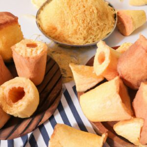 Imagem de uma pamonha cremosa feita na Airfryer. A pamonha tem uma casca dourada e crocante e um interior cremoso e macio. Ela é servida em uma tigela com manteiga derretida.
