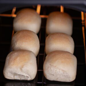 Fotografia de um pão folha assado na Airfryer. O pão está dourado e crocante, com uma crosta fina e um miolo macio e fofo. Ele é cortado em fatias grossas, revelando a textura interna arejada.