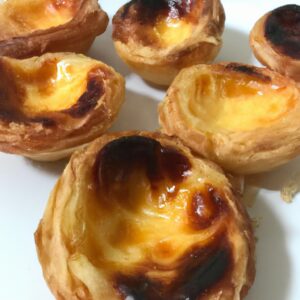 Pastel de Nata assado na Airfryer, com sua massa folhada crocante e creme de ovos cremoso, polvilhado com canela em pó.
