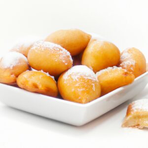 Imagem de um pastel frito em uma airfryer. O pastel é dourado e tem um recheio branco cremoso. Há uma tigela de molho vermelho ao lado do pastel.