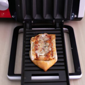 Pizza Hut Pizza Pan colocada em uma Airfryer, pronta para ser cozida. A Pizza Pan é redonda e preta, com uma crosta crocante por fora e queijo derretido e coberturas por cima.
