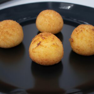 Imagem de um prato com Provoleta assada na Airfryer. O queijo está derretido e dourado, coberto com orégano e flocos de pimenta vermelha. A Provoleta é servida com fatias de pão crocante para mergulhar.