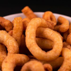 Imagem de uma porção de rabanada salgada crocante cozida em uma Airfryer. As rabanadas são douradas e cobertas com uma mistura de queijo parmesão e ervas, e são servidas com um molho de tomate à parte.