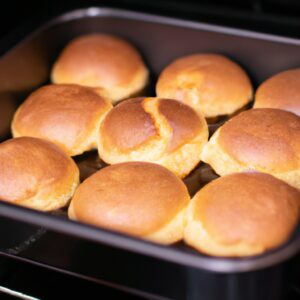 Imagem de uma deliciosa fatia de pudim de pão, feito na Airfryer. O pudim é dourado e crocante por fora, e macio e úmido por dentro. É coberto com uma colher de creme de leite fresco, que adiciona um toque cremoso e doce ao prato.