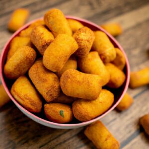 Imagem de uma Airfryer com uma cesta cheia de comida cozida, como batatas fritas, nuggets de frango e vegetais. O texto "Airfryer Receita Deliciosa" está escrito no canto inferior direito.